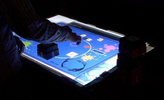A user interacting with the interacTable, using both tangible and multi-touch interactions